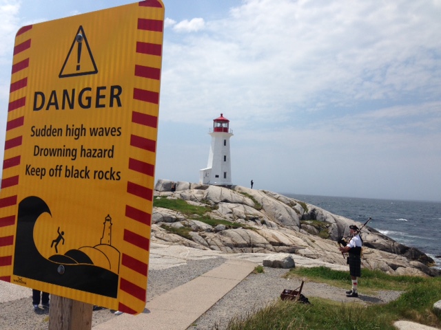 Peggy's Cove Lighthouse with warning sign and bagpipes